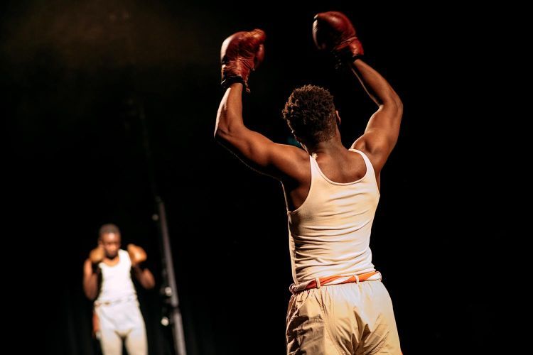Actor in boxing costume raising their arms in the air